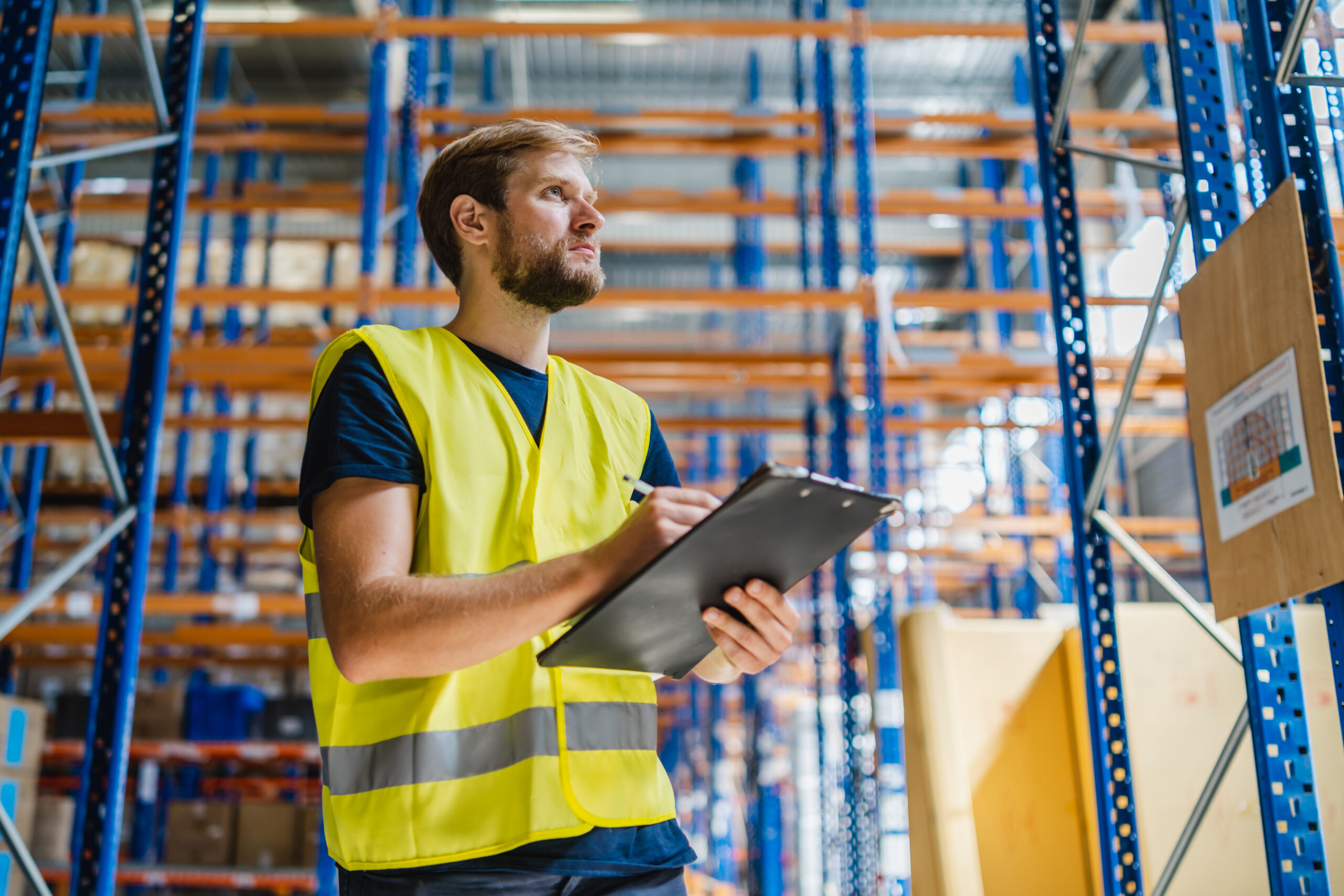 Young,Warehouse,Manager,Checking,Goods,Using,A,Clipboard,In,A